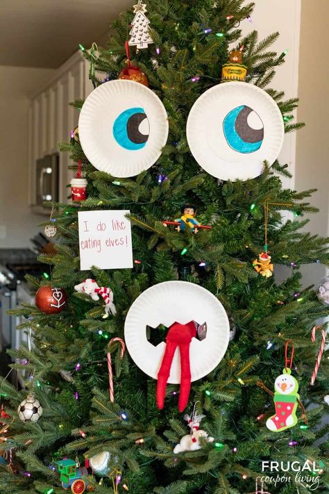 Use paper plates and make a DIY Christmas Tree Face when you create this fun Christmas Tree Monster Eating Elf on the Shelf idea. New Elf on the Shelf ideas daily plus free Elf on the Shelf printables. #FrugalCouponLiving #ElfontheShelf How To Make Your Elf On The Shelf Pregnant, Christmas Tree Elf Ideas, Elf On The Shelf Ideas With Muffins, Elf On The Shelf Tree House Diy, Elf On Shelf Thanksgiving Ideas, Elf On The Shelf In Tree Ideas, Dollar Store Elf On The Shelf Ideas, Elf On The Shelf Ideas With Christmas Tree, Easy Elf On The Shelf Ideas Marshmallows