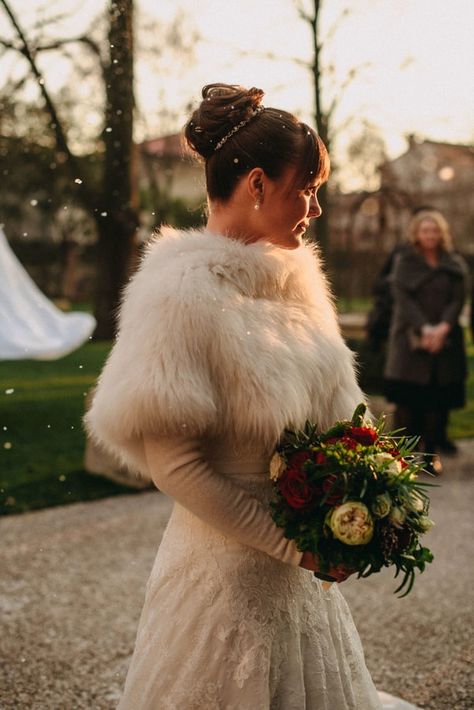 Bride wearing a shaggy fur shawl for Christmas wedding Veil Winter Wedding, Wedding Dress With Fur Cape, Wedding Shawls And Wraps Winter, Xmas Wedding Dress, Wedding Dress With Fur Shawl, Wedding Dress With Fur, Winter Bride Dress, Wedding Dresses For Winter, Yule Wedding