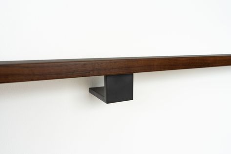 Modern, matte black, wall-mounted, handrail bracket with a black walnut handraill Modern Handrail, Wall Mounted Handrail, Stair Brackets, Modern Stair Railing, Mountain Interiors, Beautiful Stairs, Stair Hardware, Handrail Brackets, Stair Handrail