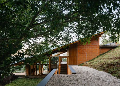 Half-slope House steps into a hillside in rural Brazil House Built Into Hillside, Houses On Slopes, Slope House Design, House On Slope, Sloping Lot House Plan, Slope House, Hillside House, Arch House, Modern Mountain Home