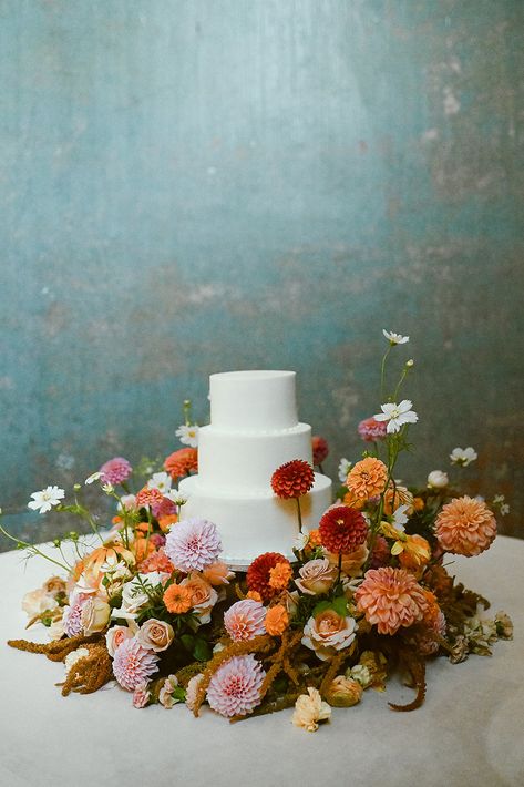 Bright Flower Wedding Cake, Flowers Around Wedding Cake, Muted Colorful Wedding, Bright Fall Wedding Flowers, Flowers Around Cake, August Wedding Ideas, Fall Elegant Wedding, Cake Table Flowers, Palace Photoshoot