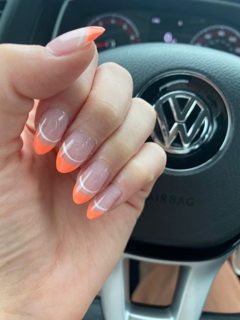 Almond shape with tangerine orange tip and a white line design. Color is “zesty vibes” Orange Nails White Tips, Nail Designs Orange And White, Orange And White Almond Nails, White Nails With Bright Colors, White French Tip With Orange Design, White Nails With Orange Tips, White French Tip With Orange Line, White And Orange French Tip Nails, Orange Prom Nail Ideas