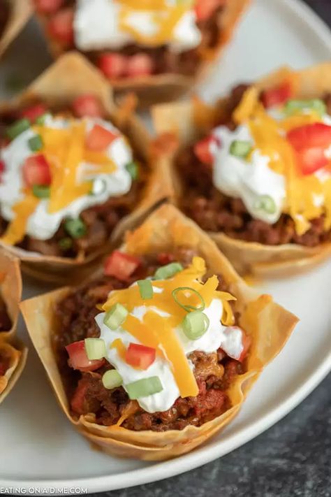 You will love these easy Wonton Taco Cups. This recipe has lots of cheese and yummy taco meat, veggies and more! Give it a try. This will quickly be one of your favorite appetizers that everyone will love! #eatingonadime #appetizerrecipes #wontonrecipes #beefrecipes Easy Taco Cups, Mexican Wontons Appetizers, Taco Wonton Cups Appetizers, Wonton Meals, Taco Appetizers Snacks, Taco Cups Wonton, Mini Tacos Appetizers, Taco Wonton Cups, Taco Wonton