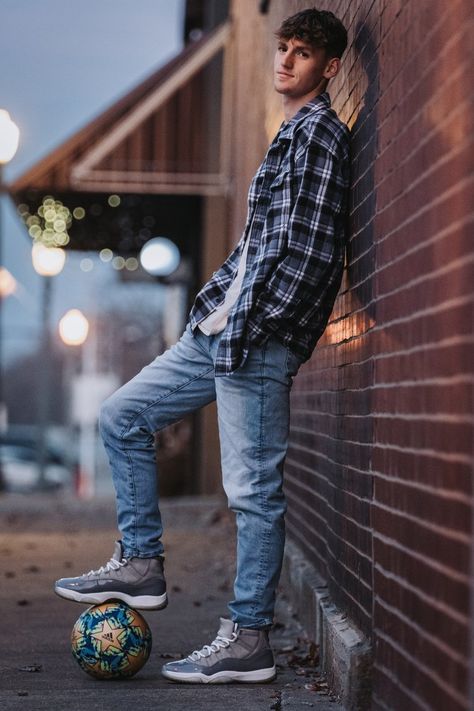 Senior boy posing with soccer ball leaning on a brick wall downtown. Senior Photoshoot Ideas For Guys Soccer, Male Senior Pictures Poses Soccer, Male Senior Photos Soccer, Guy Senior Photos Soccer, Son Senior Picture Ideas, Boy Soccer Senior Picture Ideas, Senior Pictures Soccer Boys, Senior Boy Soccer Photos, Senior Photos For Guys Posing Ideas