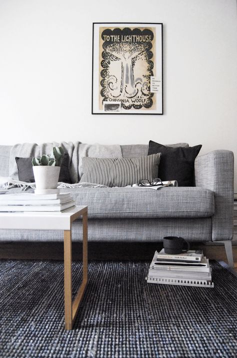 A moody monochrome living room with white walls, grey sofa and dark rug Living Room With Dark Rug, Sofa With Footstool, Dark Grey Rug Living Room, Grey Sofa Rug, Dark Rugs, Light Grey Sofa, Grey Carpet Living Room, Dark Rug, Light Gray Couch