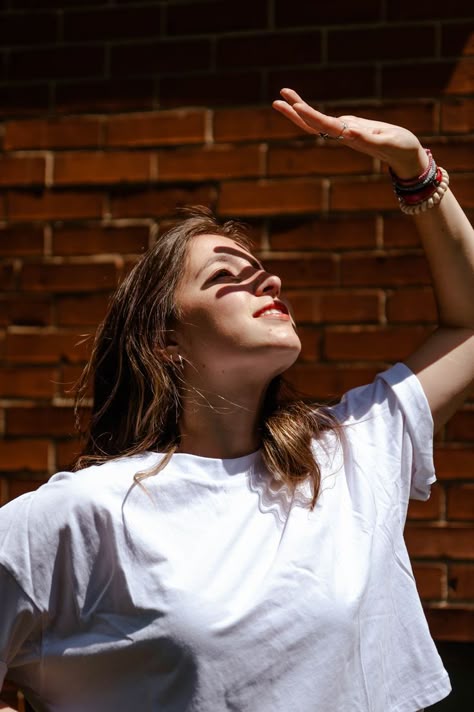 A girl with her hand up towards the sun, the shadow across her face. Hand Covering Face From Sun Pose, Covering Face From Sun Pose, Covering Eyes From Sun Pose, Blocking The Sun With Hand Pose, Hand On Forehead Reference, Shielding Eyes From Sun Pose, Hand Shielding Face From Sun Pose, Blocking Sun With Hand Pose, Looking At Hand Pose