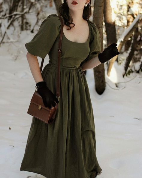 Woman in the snow wearing a dark green dress and holding a brown satchel Casual Outfits Cottagecore, Cottagecore Elegant Dress, Cottagecore Women Fashion, Moody Cottagecore Outfits, Dark Green Cottagecore Dress, Cottagecore Fall Fashion, Cottagecore Adventure Outfit, Dark Cottagecore Fashion Summer, Cottagecore Summer Dress