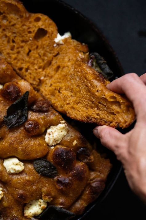 Taking a slice of freshly baked sourdough pumpkin focaccia showing the plush crumb and crisp exterior Pumpkin Sourdough Loaf, Fall Baking Sourdough, Fall Foccacia, Pumpkin Focaccia Sourdough, Pumpkin Spice Sourdough Focaccia, Pumpkin Sourdough Focaccia, Pumpkin Focaccia Bread, Pumpkin Focaccia, Pumpkin Sourdough Foccacia