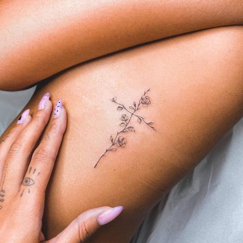 Fine line flower cross tattoo on the rib. Flower Cross Rib Tattoo, Rib Women Tattoo, Feminine Biblical Tattoos, Beautiful Cross Tattoos, Cute Tattoos For Women Ribs, Small Cross With Flowers Tattoo, Spine Tattoos For Women Cross, Spine Cross Tattoos For Women, Rib Cross Tattoos For Women