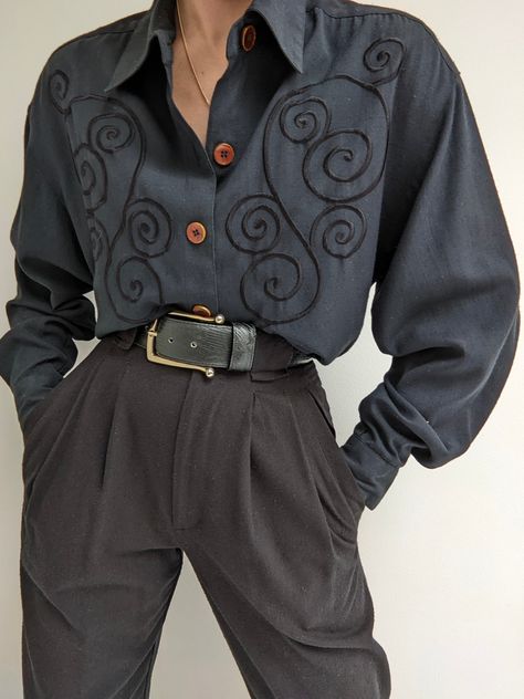 Faded black blouse with a beautiful, muted embroidered design at the front. Blouse has button closures up the front, a collared neckline and pleats at the sleeve cuffs. 100% rayon Tag reads TOTOnKo Recommended for size xs-l, depending on the desired fit. Modeled on an extra small frame. Please refer to the measurements listed below: Measures approximately: 20" shoulder to shoulder / 42" bust / 21" sleeve length / 28" shoulder to hemline There is some incredibly minor pilling. If you would like a Oc Clothes, Lady Outfits, Black Embroidered Blouse, 1970s Clothing, Pretty Clothing, Dr Closet, Character Poses, Formal Casual, Small Frame