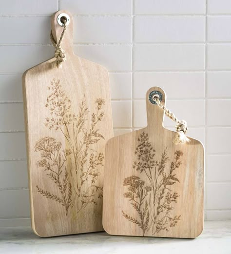 Handcrafted in Thailand, these nature-inspired Wildflower Etched Serving Boards made from natural mango wood are delicately etched with a wildflower design that graces these chic yet rustic boards. Pretty enough to hang on a wall yet perfectly sized to showcase a delightful cheese and charcuterie spread. Arrives with an attached jute cord for easy hanging. V4915,Wildflower Etched Serving Boards,Rectangle,serving board,wildflower,rustic,mango wood,handcrafted,chic Etching Wood, Ginkgo Design, Closed Terrarium Plants, Charcuterie Spread, Wooden Serving Boards, Wildflower Design, Woodburning Projects, Flora Design, Laser Engraved Ideas