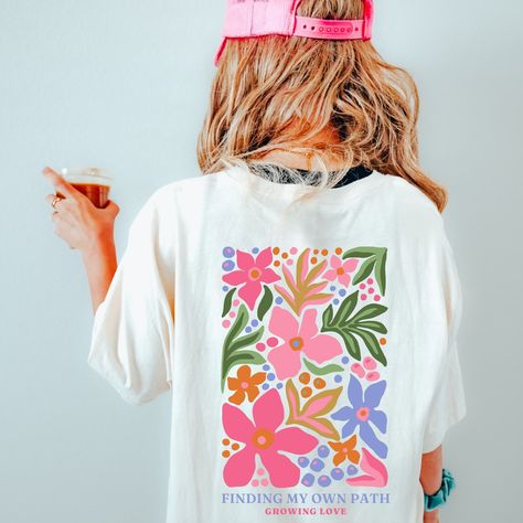 A breezy, lightweight shirt featuring a vibrant tropical floral print. Perfect for a day at the beach or a summer evening out. #tropical #floral #shirt / #Summer_Shirts_For_Women #Hippie_T_Shirt #Hippie_T_Shirts #Women_Design Hippie T Shirt, Hippie T Shirts, T Shirt Flowers, Flower Shirt, Beach Shirts, Apparel Design, Summer Tshirts, White Sweatshirt, Design Style