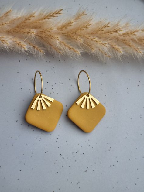 Beautifully unique rounded square ochre polymer clay earrings with a gold coloured fan charm on a gold plated hoop. These fun little fashion accessories are: ❤ handmade and one of a kind, therefore no two will ever be exactly the same ❤ made from super lightweight polymer clay so you can wear them all day - they are so comfortable, you will likely forget you have them on! ❤ finished with hypoallergenic gold plated hoops  The earrings are lovingly handcrafted by me and I take pride in making every set as beautiful as possible, however, due to their handmade nature, there may be slight variations compared to the picture and there may be minor imperfections in each piece. ORDER INFORMATION - your item will be: ★ dispatched within 1-3 business days ★ posted using Royal Mail  ★ beautifully and Polymer Clay Earrings With Gold Findings, Gold Leaf Polymer Clay Earrings, Hoop Earrings With Charm, Earring Clay, Clay Hoop Earrings, Boho Hoop Earrings, Diy Earrings Polymer Clay, Boho Earring, Polymer Earrings