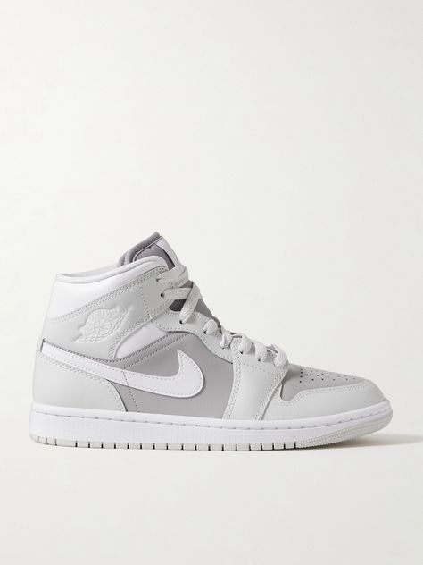 Nike's 'Air Jordan 1 Mid' sneakers are inspired by the very first pair, offering fans a look at how far the style has come since its launch in 1985. They're made from panels of tonal-gray and white leather and detailed with the iconic 'Swoosh' logos. Nike Air Jordan 1 Mid, Sneakers Grey, Air Jordan 1 Mid, Jordan 1 Mid, Air Jordan 1, Nike Air Jordan, Leather Sneakers, Jordan 1, White Leather