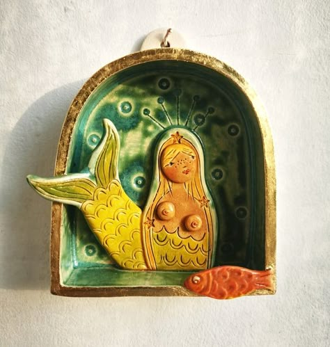 A handmade ceramic wall sculpture depicting a blond mermaid with starfish studded hair.Made from stoneware clay and fired to 1160 degrees. Glazed with underglazes and glaze, gilded with gold coloured metal leaf.Height 10 cmWidth 9cmDeoth 2.5 cm Brunette Mermaid, Wall Shrines, Shrines Art, Ceramic Wall Sculpture, Mermaid Cove, Cerámica Ideas, Clay Wall Art, Pottery Handbuilding, Ceramic Wall Art