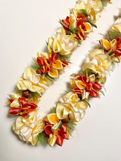 Tangerine & Carnation Delight Satin Ribbon Lei.  38" length and ~1.5" width.   Lei is made from alternation sections of folded petals and gathered florets.   Folded petal sections are made from tangerine and yellow satin ribbon that are individually cut, folded and sewn into the lei.   Tangerine petals have special curry satin ribbon with iridescent edge stamens that are individually cut, knotted and sewn together with each petal into the lei.  Yellow petals have a smaller curry iridescent sheer petal that is cut, folded and inserted into the larger petal and sewn together into the lei.  Each ivory and yellow floret is individually hand gathered and sewn.   Curry Sheer smaller florets creates the centers of the plumeria clusters.  Lei is embellished with strips of ombré moss satin ribbon, Teunga Tauolunga, Diy Lei, Grad Leis, Lei Diy, Money Lei Diy, Lei Ideas, Graduation Leis Diy, Lei Making, Hawaiian Crafts