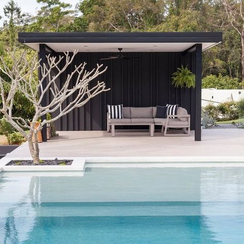 a minimalist black pool cabana with striped pillows on a single upholstered sofa for those who dont' like anything excessive Pool House Ideas Backyards, Cabana Ideas Backyard, Pool Cabana Ideas, Pool Gazebo, Pool Pergola, Modern Pool House, Pool Diy, Pool Cabanas, Pool Shed