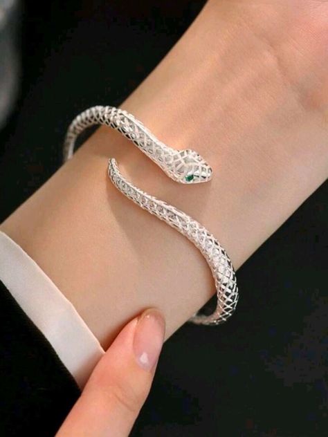 Unleash your inner serpent with this Adjustable Silver Snake Bangle! Featuring a sleek, coiled design that wraps gracefully around your wrist, this bangle symbolizes transformation and power. Its adjustable fit ensures it slips comfortably onto any wrist, making it a versatile accessory for any outfit or occasion. Whether you're drawn to its bold, edgy look or its deeper symbolism of rebirth and resilience, this snake bangle is a statement piece that commands attention. Embrace your unique style and let this serpent be a stylish reminder of your strength and evolution. Make it yours today! Ouroboros Bracelet, Ouroboros Jewelry, Cool Bracelets, Chunky Silver Bracelet, Gifts For Young Women, Silver Snake Bracelet, Snake Bangle, Popular Bracelets, Snake Lovers