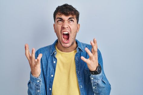 Young hispanic man standing over blue background crazy and mad shouting and yelling with aggressive expression and arms raised stock image Background Crazy, Hispanic Men, Man Standing, Blue Background, Blue Backgrounds, Anger, Stock Images, Animals, Blue