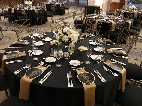 Awards Dinner Centerpieces, Black And Gold Round Table Setting, Black Gold Tablescape, Black And Gold Round Table Decorations, Black And Gold Engagement Party Decor, Black And Gold Wedding Reception Decor, Black And Gold Casino Theme Party, Black White And Gold Table Decorations, Black And Gold Banquet Decorations