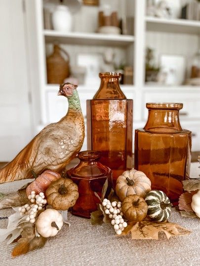 Cozy fall staples. Amber jars, fall foliage, and a pheasant. 🎃🍂 #LTKSeasonal #LTKhome Amber Glass Decor, Amber Glass Bottles Bathroom, Vintage Amber Glass Decor, Amber Colored Glass Vase, Amber Antique Glassware, Vintage Amber Glassware, Fall Staples, Amber Jars, Amber Glass Bottles