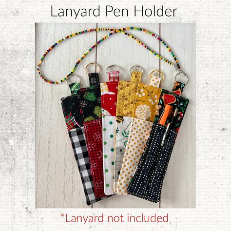 "Never lose your pen again! The Lanyard pen holder keeps your writing utensils secure and close at hand.   *Holds pens, pencils or skinny markers   *7\" long by 2\" wide   *Metal ring easily attaches to any lanyard This clever holder keeps your pen or pencil tethered to your lanyard, so you'll never have to waste time searching for a writing tool again. The slim design fits pens, pencils and skinny markers while taking up minimal space on your lanyard. The Lanyard pen holder is perfect for teach Fabric Pen Holder, Pen Lanyard, Lose Your Pen, Sewing Sayings, Lanyard Diy, Pen Keychain, Lanyard Accessories, Pencil And Pen, Teachers Office