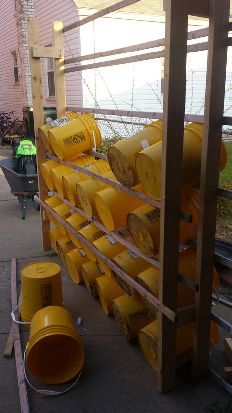 5 Gallon bucket wall in progress.  Probably designed for storage, but possibly a container garden set-up? 5 Gallon Bucket Shelving, 5 Gallon Bucket Food Storage Ideas, Bucket Storage Ideas 5 Gallon, 5 Gallon Bucket Storage Ideas, Bucket Storage Ideas, 5 Gallon Bucket Ideas, Garage Hanging Storage, Tool Shed Organizing, Easy Garage Storage