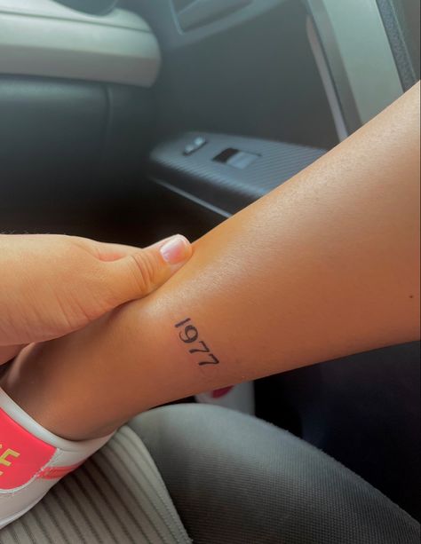 Year Tattoo On Back Of Arm, Ankle Year Tattoo, Dainty Birth Year Tattoo, Birthdate Tattoos For Women, Birth Year Tattoo Placement, 1932 Tattoo, 1977 Tattoo Ideas, Birthdates Tattoos, Year Tattoos For Women