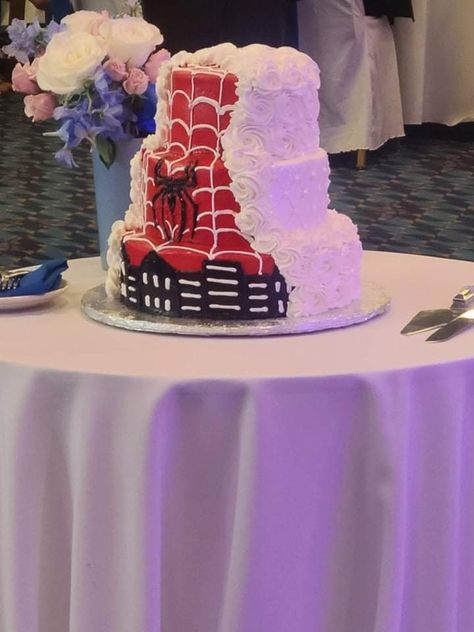 This is a 3 tier wedding cake on a table. One side of it is white with rosettes on the top and bottom tier and just a dot pattern on the middle tier.  The other side of the cake has a red background with white webbing. There is a Spiderman emblem on middle tier and the outline of a city on the bottom tier. Spiderman Wedding Cake, Spiderman Birthday Cake Ideas, Spiderman Wedding, Hello Kitty And Spiderman, Spiderman Birthday Cake, Spiderman Gifts, Spiderman Theme, Spiderman Cake, Birthday Cake Ideas