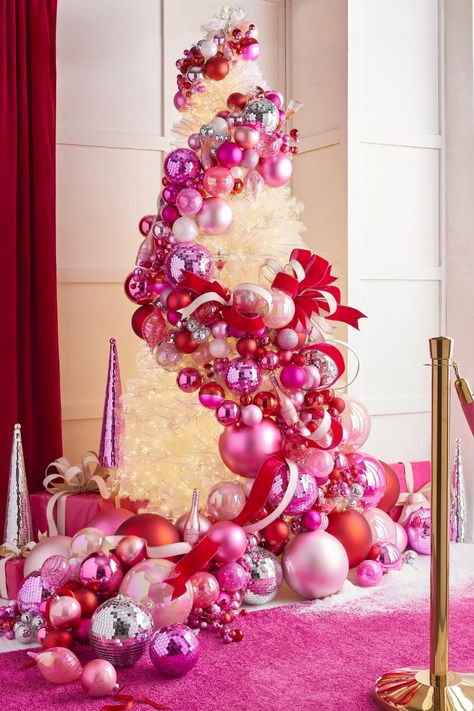 the 2024 A Blushing Holiday Christmas Tree from RAZ Christmas Tree Ball Garland, Pink Xmas Tree Decorating Ideas, Garland Archway Christmas, Christmas Pink Decorations, Red And Pink Christmas Decor, Pink Ornaments Christmas Tree, Pink And Red Christmas Tree, Pink And Red Christmas Decor, Pink And Green Christmas Tree