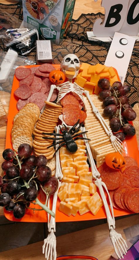 Things you need 👻
-Walmart meat, cheese, and cracker platter. 
-Purple grapes 
-Family Dollar Skeleton 
-Dollar Tree Mini Pumpkins
-Candy Corn (optional) Halloween Board Ideas Food, Boo Charcuterie Board Letters, Diy Halloween Charcuterie Board, Halloween Party Fruit Tray, Halloween Food Charcuterie Board, Skeleton Fruit Tray, Halloween Cheese Boards, Halloween Party Food Boards, Halloween Bring A Board