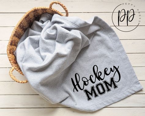 "Show off your pride for you little (or big) hockey player with this cute \"Hockey Mom\" design. It is shown here in black vinyl on a grey blanket. We offer the blankets in black ONLY and the designs can be made in a multitude of colors as can be seen in our vinyl color chart in the listing photos to meet your team colors or even just your favorite colors. Please make your selection and note the colors desired specifying glitter or regular, in the personalization box along with your personalized Hockey Bedding, Hockey Nursery, Hockey Blanket, Hockey Stadium, Hockey Mom Gifts, Grey Blanket, Mom Blanket, Hockey Decor, Baby Ads