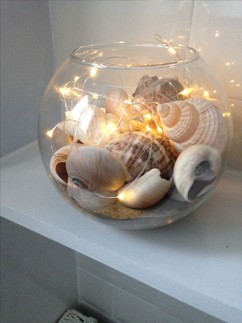 Sand,shells & micro lights in a goldfish bowl new decoration for downstairs 🚾 Beach Bowl Decor, Creative Fish Bowl Ideas, Goldfish Decor, Seashell Art Diy, Deco Marine, Diy Beach Decor, Goldfish Bowl, Shell Crafts Diy, Sea Shell Decor