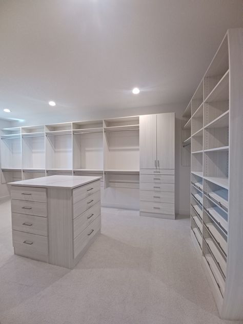 custom closet for a new custom home! These clients had an amazing space to work with, giving plenty of space for hanging, shoes, and island, and built-in storage below windows #closetgoals Big Closet With Island, 2 Level Closet, Walk In Closet Centre Island, Island For Walk In Closet, Large Master Closet With Island, Walk-in Closet Island Ideas, Island Storage, Closet Island, Hanging Shoes