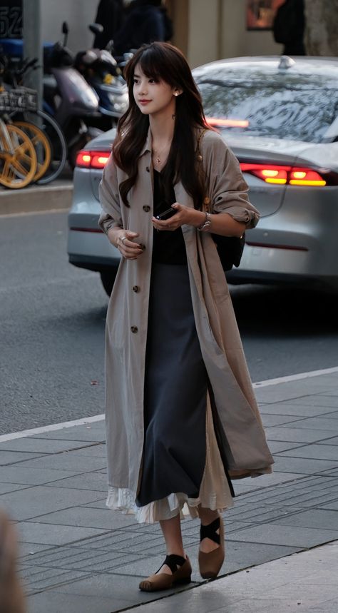 Urban Chic in a Beige Trench Coat Step up your street style game with this effortlessly chic outfit. The long beige trench coat adds a touch of elegance, while the layered skirt and black top create a sophisticated silhouette. Paired with comfortable flats and minimal accessories, this look is perfect for a day out in the city. #StreetStyle #TrenchCoat #UrbanFashion #ChicOutfit #CityLook #FashionDaily #OOTD #StyleInspo #EffortlessElegance #TrendAlert Layered Skirt Outfit, Trench Coat Outfit, Beige Trench Coat, Fashion Silhouette, Flats Outfit, Minimal Accessories, Beige Outfit, Asian Street Style, Effortlessly Chic Outfits