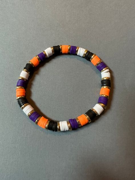 Orange, purple, black, and white clay bead bracelet with gold metal spacer beads.  Bracelet made with elastic string. Length is approx 7 inches unstretched.  Need a different size? Message me for custom options! Clay Needs Bracelets, Fall Loom Bracelet, Halloween Braclets Idea, Halloween Jewelry Diy Bracelets, Preppy Halloween Clay Bead Bracelets, Clay Beads Ideas Halloween, Halloween Clay Bead Ideas, Bracelets To Make And Sell, Grunge Clay Bead Bracelets