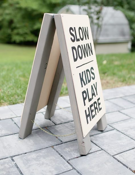 Make this slow kids at play sign DIY wooden frame sign from scrap 2x4 wood. Diy Slow Down Sign, Standing Wood Sign, Diy Folding Sign, Diy Outdoor Signs Business, Sandwich Board Signs Diy, Diy Sandwich Board Sign, A Frame Sign Ideas, A Frame Sign Diy, Diy Sidewalk Sign