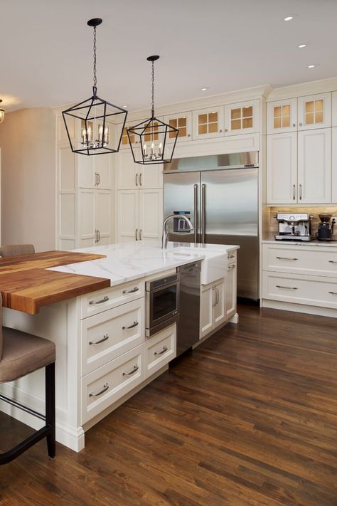 Traditional White Kitchen with White Shaker Cabinetry, Glass Insert Upper Cabinetry, Crown Moulding, Butcher Block & Granite Island with Distressed Hardwood Flooring. Designer: Michael Burr . . . . #kitchen #kitchendesign #kitcheninspo #kitchenrenovation #kitchenreno #traditionalkitchen #whitekitchen #whitecabinets #kitchenisland #glasscabinets Hexagon Kitchen Island, Butcher Block Island With Seating, Kitchen Island Extension, Kitchen With Butcher Block Island, Island Extension, Traditional White Kitchen, Wood Extension, Granite Kitchen Island, Kitchen Cabinets Color Combination