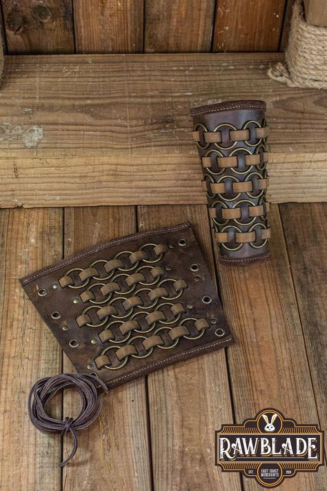 Introducing our Fighter Bracers, a formidable pair of leather armguards that exude the spirit of the medieval warrior. These bracers, adorned with metal rings intricately woven into leather strips, offer both protection and style, making them an essential accessory for LARP, historical reenactment, rennaisance fairs, and medieval events. Part of our esteemed Fighter product series, these bracers are meticulously crafted from high-quality leather, ensuring durability and reliability on the battle Armor Craft, Arm Guards, Medieval Aesthetic, Historical Reenactment, Leather Armor, Leather Projects, Fantasy Clothing, Larp, Canvas Leather