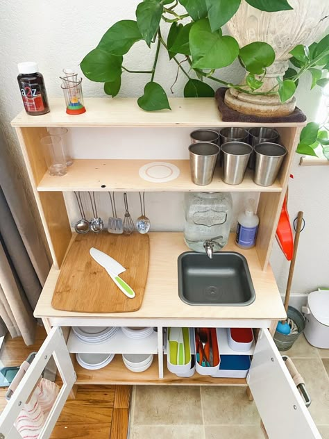 Practical Montessori Kitchen For A Toddler – a little bit of essence Play Kitchen Classroom, Wooden Play Kitchen Diy, Montesorri Playroom Ideas, Montessori Kitchen Setup, Montessori Dining Area, Montessori Play Kitchen Diy, Play Kitchen Montessori, Montessori Eating Area, Montessori Fridge