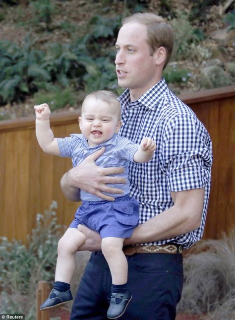 Britain's Prince George reacts in his father Prince William's arms after looking at an Australian animal called a Bilby, which has been name...