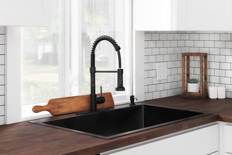 A black kitchen sink and faucet detail in a white kitchen with a butcher block countertop. stock photography White Butcher Block, Black Kitchen Sink, White Subway Tile Backsplash, Subway Tile Backsplash, White Subway Tile, Butcher Block Countertops, Kitchen Sink Faucets, Cozy Decor, Black Kitchens