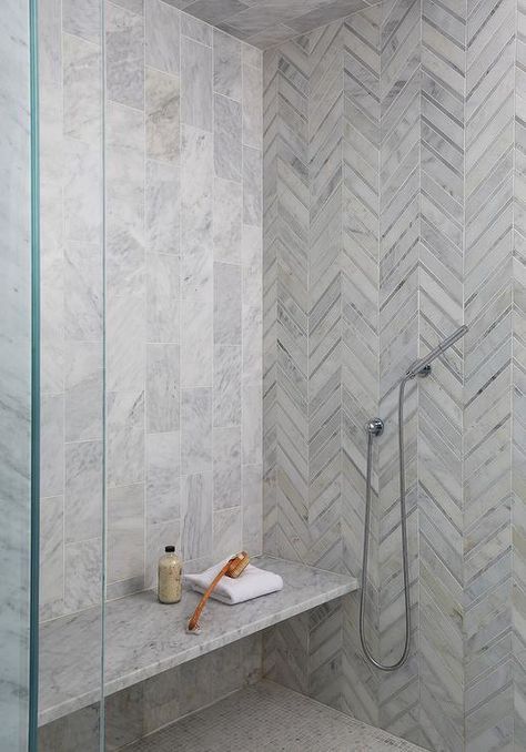 A marble slab bench is fixed over marble grid floor tiles and against staggered vertical marble wall tiles in a seamless glass walk-in shower. Herringbone Tile Bathroom, Shower Accent Tile, Marble Shower Walls, Calcutta Gold Marble, Calcutta Gold, Accent Wall Design, Trendy Bathroom Tiles, Shower Wall Tile, Marble Wall Tiles