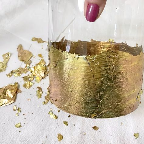 Decor, DIY, How-TosMaking a DIY gold leaf vase is the perfect way to turn an ordinary unused, thrifted, or Dollar Store glass vase into an extraordinary one. Add beauty and shine to any glass vase or bottle with this quick and easy project. Y’all, I’m obsessed! If you’ve been with me for any length of time, you know that when I try an easy DIY and I fall in love with it, nothing is safe in our home. I just keep making pieces until I run out of supplies. This DIY is no different. Not… Gold Leaf Ideas, Dollar Tree Gold Leaf, Gold Foil Vase Diy, Spray Paint Glass Vases Gold, Gold Vase Decor, Gold Glitter In Water Vase, Diy Spray Paint Glass Vase Gold, Area Aesthetic, Diy Gold Mercury Glass Vase