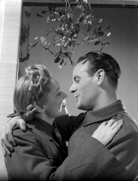 30th November 1939: An Auxiliary Fire Servicewoman and a British Army private kissing under the mistletoe. (Photo by Fox Photos/Getty Images) Kiss Under Mistletoe, Mistletoe Photo, Kissing Under Mistletoe, Why Do We Kiss, Kissing Under The Mistletoe, Christmas Couple Photos, Christmas Photograph, Christmas Eve Traditions, Cute Kiss