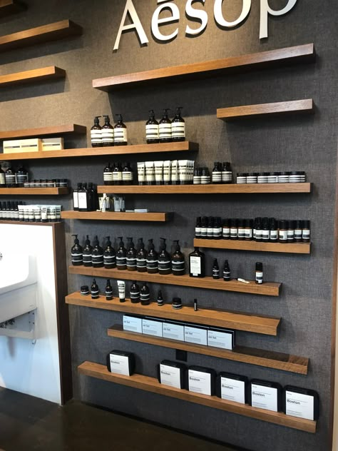 Barbershop Product Display, Dark Retail Interior, Cologne Display Ideas, Hair Salon Feature Wall, Toko Parfum, Store Product Display, Skin Care Retail Display Ideas, Vapeshop Interior Design, Perfume Shop Design Ideas