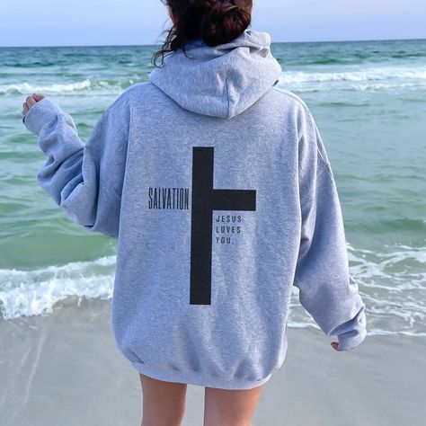 "Faith-Inspired Jesus Loves You Hoodie - a warm and comforting addition to your wardrobe that beautifully combines faith and style. This cozy sweatshirt bears the heartwarming message, \"Jesus Loves You,\" serving as a powerful reminder of the boundless love that Jesus has for you and all who believe in Him. In addition to this inspiring message, the hoodie features a Christian cross, symbolizing the ultimate sacrifice and salvation that Jesus brought to the world.  This Christian hoodie is perf Jesus Loves You Shirts, Christian Hoodies Aesthetic, Love Like Jesus Shirt, Jesus Sweaters, Cute Hoodie Designs, Christian Sweatshirt Designs, Jesus Hoodies, Jesus Sweater, Loves You