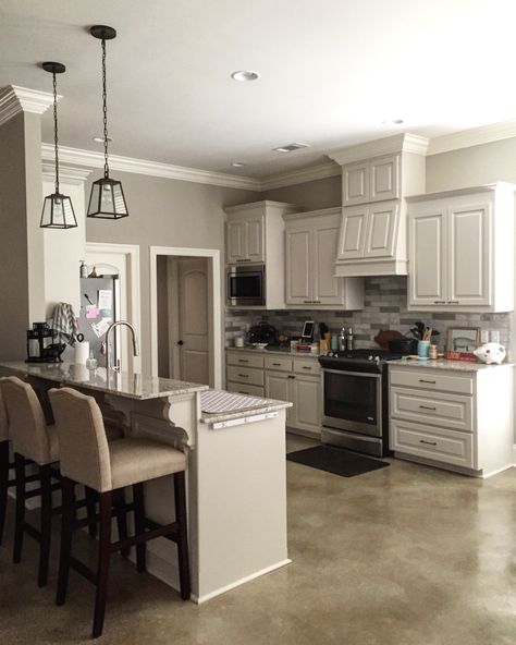 The wall color is Benjamin Moore Revere Pewter (HC-172); the cabinets are Benjamin Moore Edgecomb Gray (HC-173); the trim is Benjamin Moore White Dove (OC-17) | Travertine tile backsplash - I painted the darker tiles in Clark+Kensington Baby Elephant (3052) | 2cm Giallo Ornamental granite | Revere Pewter Cabinets, Pewter Cabinets, Revere Pewter Kitchen, Benjamin Moore Revere Pewter, Trendy Farmhouse Kitchen, Revere Pewter Benjamin Moore, Edgecomb Gray, Interior Paint Colors Schemes, Selling Ideas