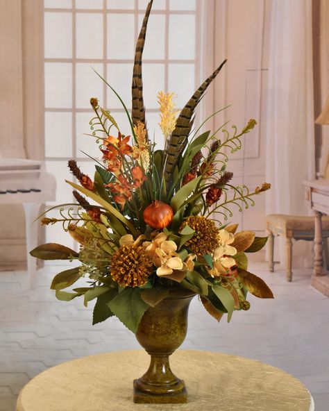 A unique floral design perfect for smaller spaces, requiring  height and  lots of style.  Set this gorgeous design on  a mantle, dresser, end table, desk or shelf. Just to name a few.  Created with fern, heather, pomegranate, foliage, grasses, and pods in warm tan and rust tones. Fall Grass Arrangements, Fall Feather Centerpieces, Fall Floral Arrangements For Church, Fall Flower Centerpiece, Large Fall Floral Arrangements, Fall Floral Arrangements Wedding, Fall Arrangements Floral Design, Masculine Floral Arrangements, Fall Vase Arrangements