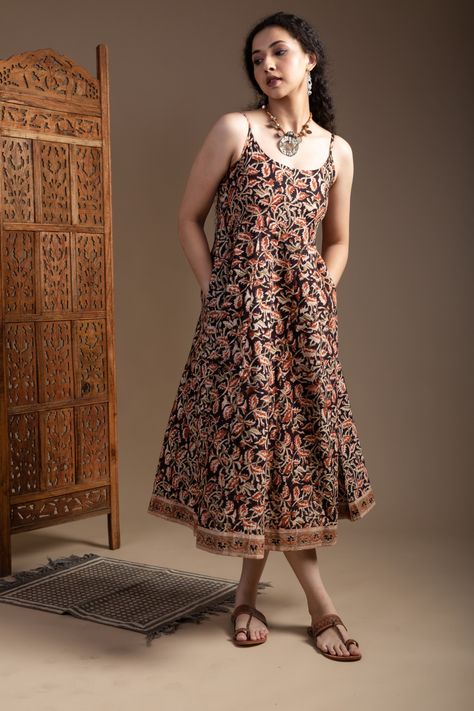 The cotton dress is designed in an A-line style with a beautiful Kalmakari print, which adds a traditional touch to its modern design. It comes in classic black color with a panel highlighted with a border, giving the dress a defined and structured look. The round neck and sleeveless design make it perfect for warm weather, and the dress has both side pockets to add convenience to its style. The back of the cotton dress features an elastic panel that allows for easy adjustment of the fit, ens... Cotton Dress Pattern Indian Summer, Sleeveless Churidar Designs, Cotton Dress Pattern Indian, Kalamkari Dress, Cotton Dress Pattern, Sleeveless Kurta, Kalamkari Dresses, Women Dress Collection, Kalamkari Painting